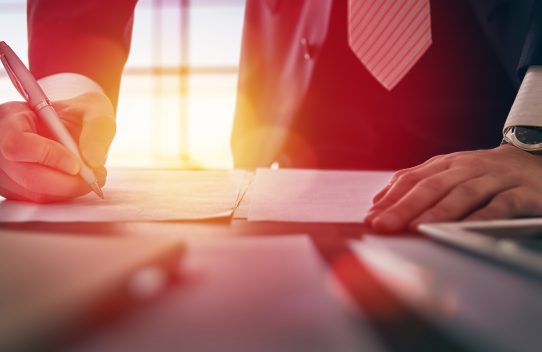 Close up businessman signing documents.
